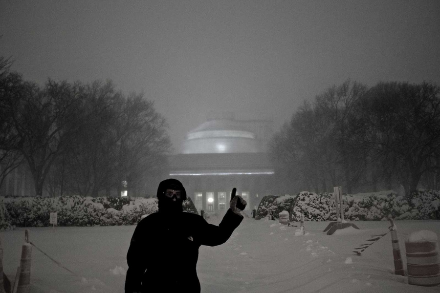 A passerby in front of the illuminated Great Dome as the blizzard neared its peak on Friday night.