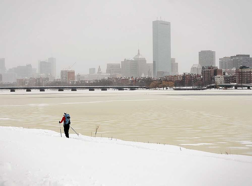 A lone individual skied along the Charles River.