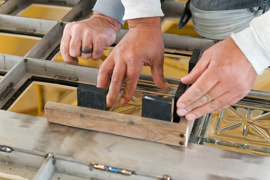Placing individual replicated glass blocks in new steel skylight frame.