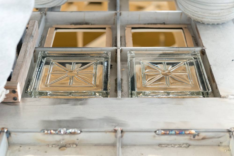 Placing individual replicated glass blocks in new steel skylight frame.