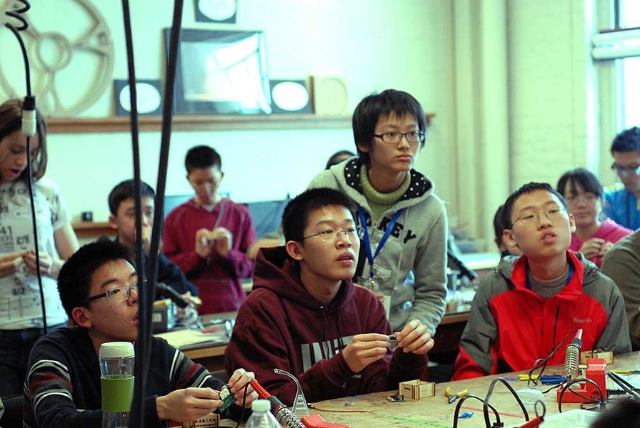 Students pay close attention as they learn how to build LED light boxes with integrated circuits.