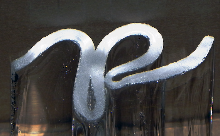 Letter 'P' cut on side of glass.