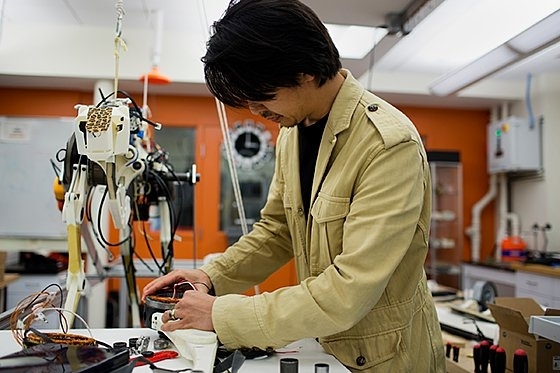 Assistant Professor Sangbae Kim works on the 70-pound 'cheetah' robot designed at MIT.