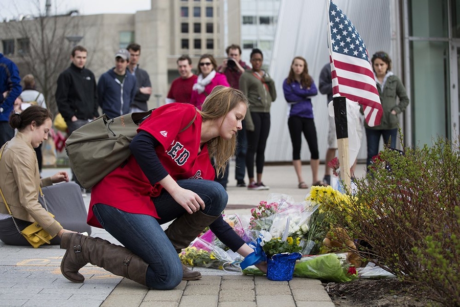 Woman laying down flowers at a memorial