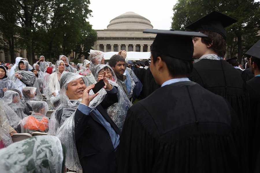 Graduates, family, friends and guests do their best to stay dry during the rainy ceremony.