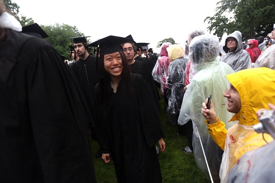Graduates, family, friends and guests do their best to stay dry during the rainy ceremony.