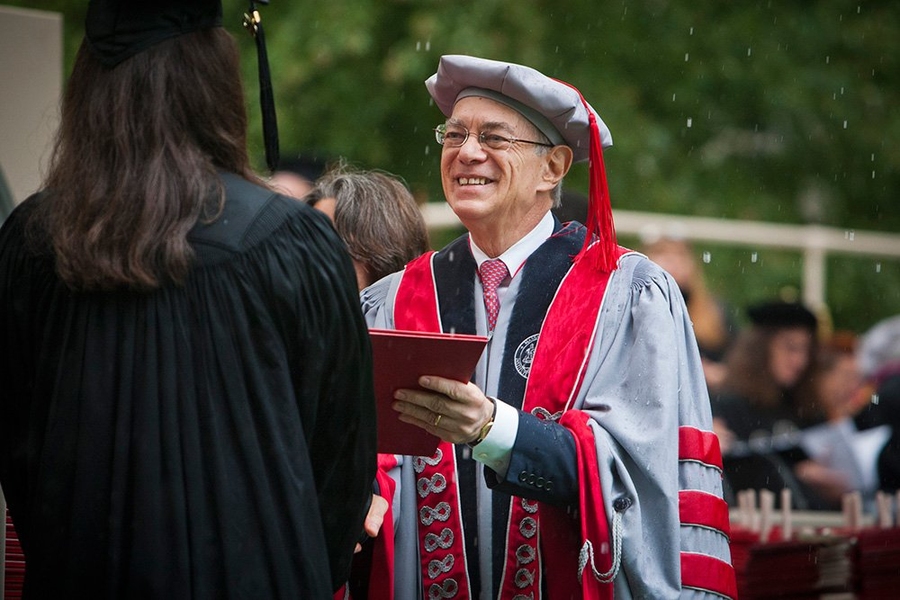 President L. Rafael Reif hands a diploma to a new graduate.