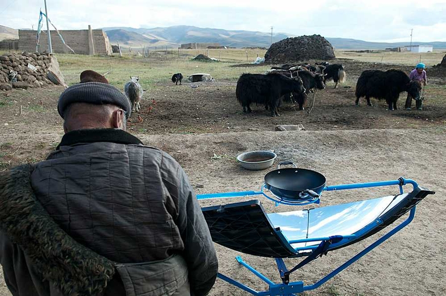 A nomad on the Himalayan Plateau uses the SolSource cooker to heat water and food for yaks.