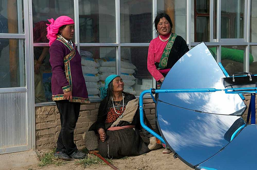 Women on the Himalayan plateau gather around the SolSource. One Earth Designs founder Scot Frank '08 says the cooker has saved women in the region a lot of time and money.