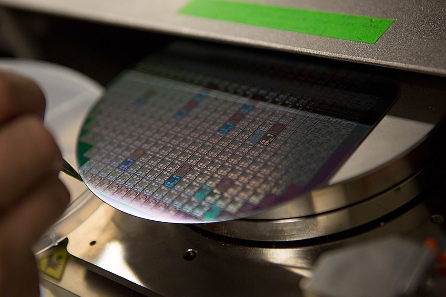 A wafer with hundreds of gallium nitride chips etched into its surface emerges from the MTL production line.