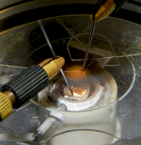 A lanthanum strontium cobaltite (LSC113) thin film in preparation for electrochemical impedance spectroscopy testing. The setup allows for measurement of a sample's oxygen surface exchange kinetics at high temperature and controlled atmosphere.
