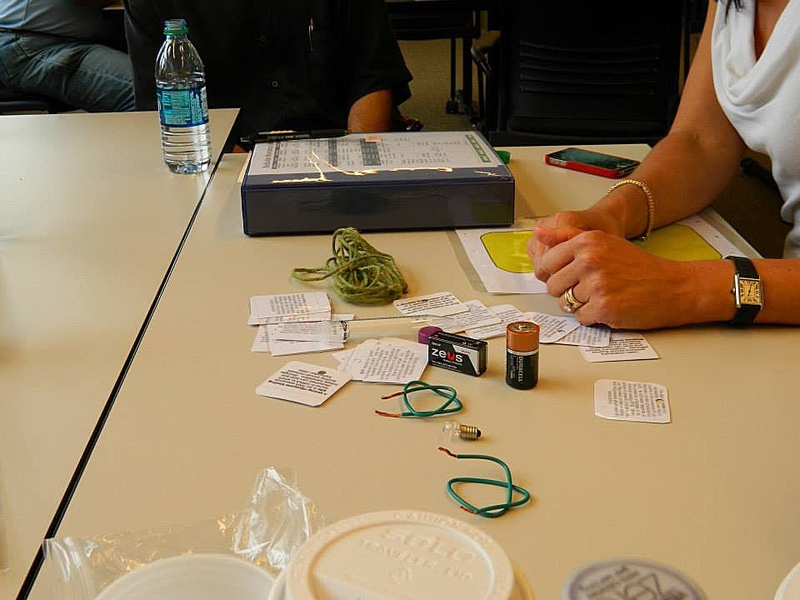 With yarn, cards, wires, batteries and light bulbs, educators modeled genetic circuits and demonstrated the similarity to electric circuits.