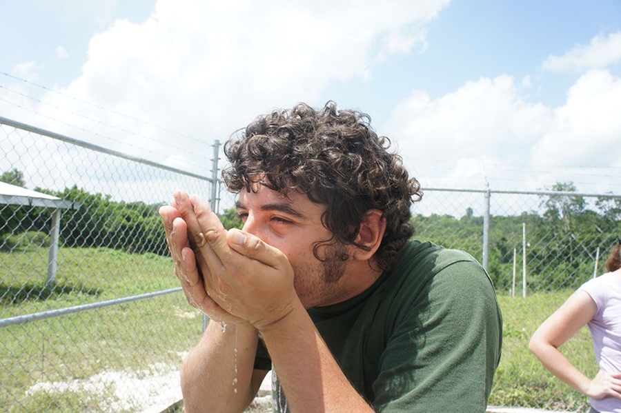 A Mexican member of the team takes the first sip of the purified water produced by the system.