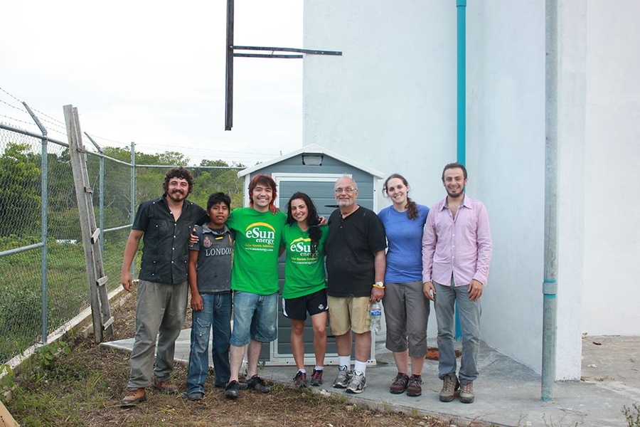 MIT/Fondo Para la Paz team members and village volunteers pose in front of the system.