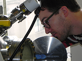 Aimon peers into the chamber of a pulsed laser deposition chamber, which is used to create thin films of complex metal oxide.
