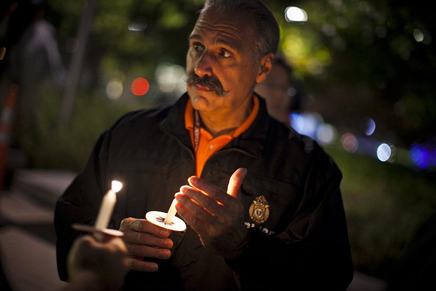 John DiFava, MIT’s director of facilities operations and security, holds a candle during the moment of silence to honor slain MIT Officer Sean Collier.