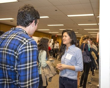 Qui Nguyen, '15, discusses with another participant her smartphone app that monitors a medical disorder through an image-processing algorithm.