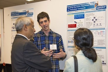 Entrepreneur and MIT trustee Desh Deshpande (left) listens to Matt Susskind, '15, a VMware Undergraduate Research and Innovation Scholar, explain his work with CSAIL principal researcher Una May O’Reilly on best online learning practices in building MOOCs.