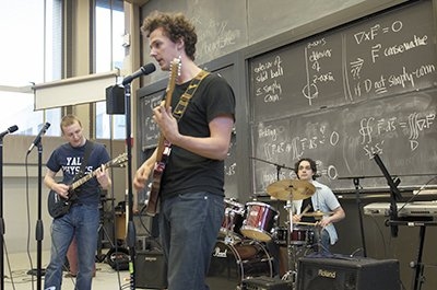 On stage at the 2010 Physics Rock Concert, an annual event organized by the MIT Society of Physics Students, are (from left) students Axel Schmidt and Michael Grinich with Professor Tali Figueroa-Feliciano. 