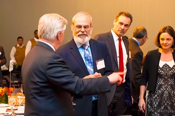 Chancellor Eric Grimson (center) and MIT Sloan Dean David Schmittlein talk with Philip Budden, MIT REAP’s diplomatic advisor, and Associate Dean Fiona Murray.