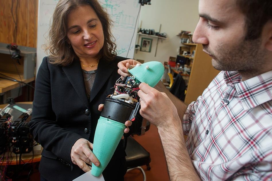 Andrew Marchese, doctoral candidate in EECS (right), and Daniela Rus, professor in EECS and Director of CSAIL, hold a soft robotic fish developed by the Distributed Robotics Laboratory. 