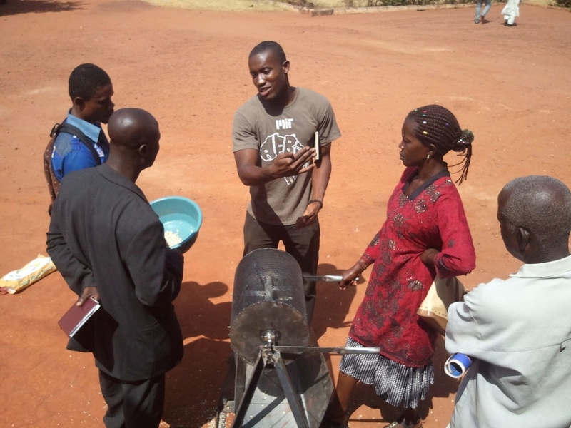 Kwami Williams (center, in an MIT shirt) at a Moringa training workshop in Techiman, Ghana in February 2013. He is explaining the technologies to process Moringa seeds in our effort to help farmers generate income from this underutilized component of the Moringa tree.