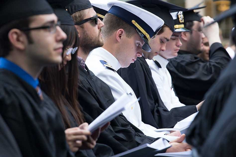 Close-up of seated graduates, some in naval uniform.