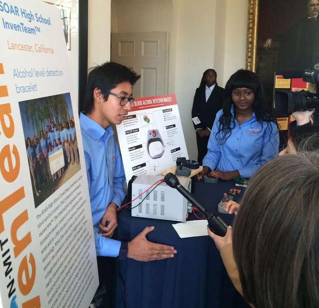 Jonathan Hernandez (left) and Fanta Sinayoko explain their blood-alcohol-detecting wrist band to members of the press.