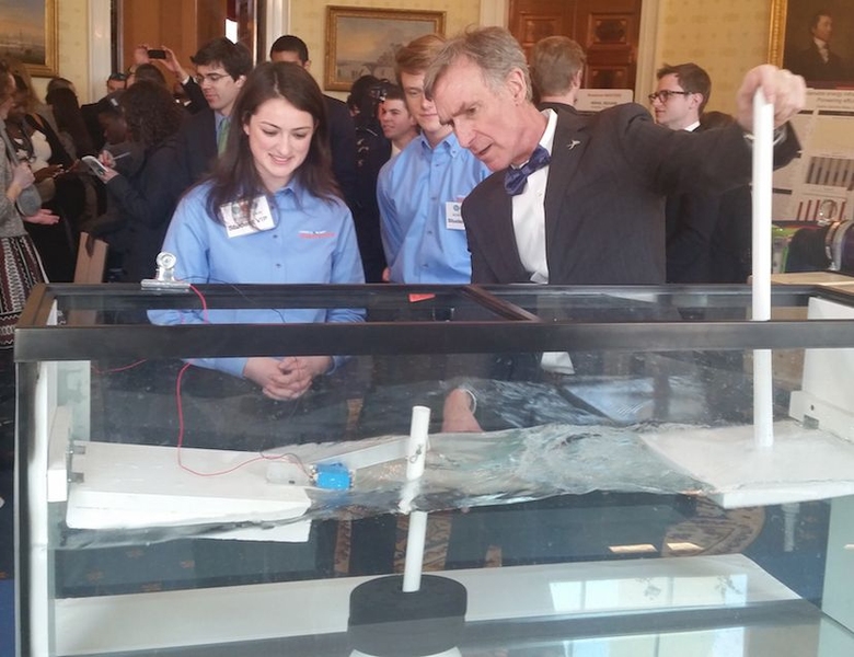 Corine Peifer (left) and Kristian Sonsteby (center) demonstrate their power-producing boat dock to Bill Nye, the "Science Guy."