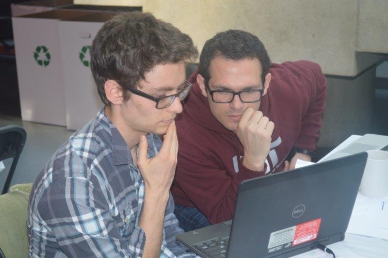 Course 1 PhD candidate David Hagan, right, brainstorms a hackathon solution with fellow Kroll Group member Mark Goldman.