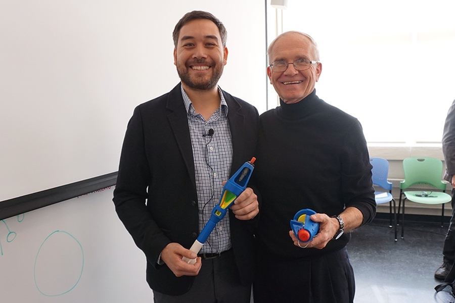 Allen Tan (left) of the Golden West Humanitarian Foundation and MIT Professor J. Kim Vandiver hold 3-D-printed advanced ordnance training materials.