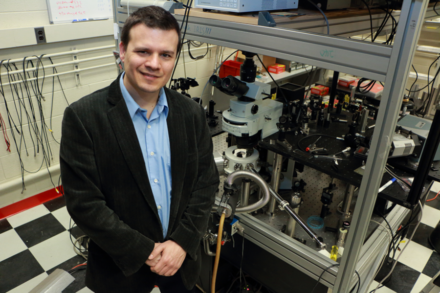 Pablo Jarillo-Herrero, the Mitsui Career Development Associate Professor of Physics, stands at a scanning photocurrent microscopy set up where samples are mounted in a cryostat, which can cool down to 4 kelvins. The set up can measure light excitation and current. 