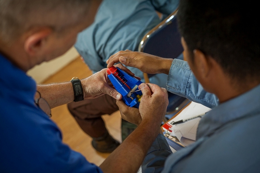 Explosive ordnance technicians work with 3-D printed models to learn how different unexploded shells and land mines work.