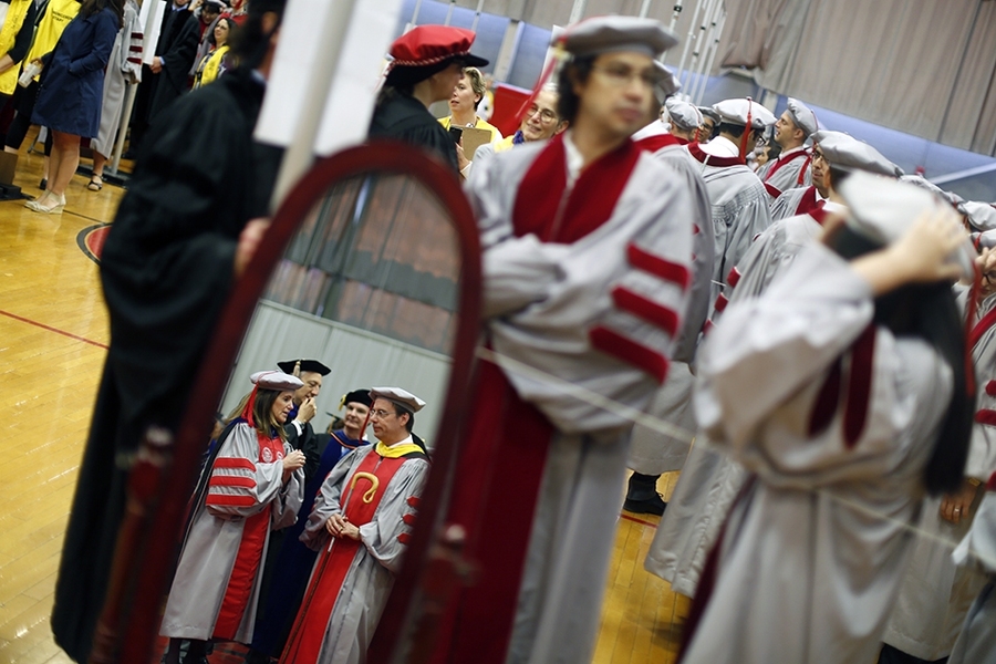 Students suit up and mingle before the hooding ceremony. Chancellor Cynthia Barnhart, who presided over today's ceremony, and Steven Hall, professor of aeronautics and astronautics and chair of the MIT faculty, are seen in the foreground in the mirror.