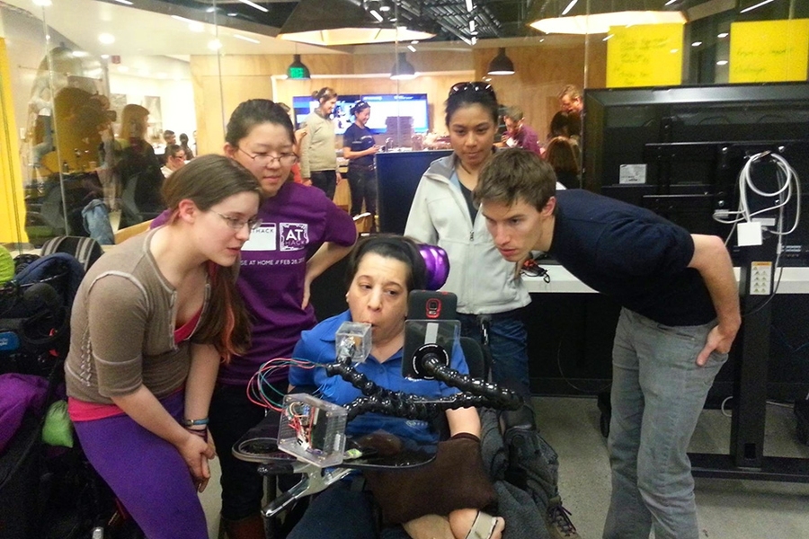 Team Adriana members (left-right) Kate Tatar, Esther Jang, Shirlene Liew, and Ned Burnell watch anxiously as Adriana Mallozzi (center) tests their prototype at the ATHack.
