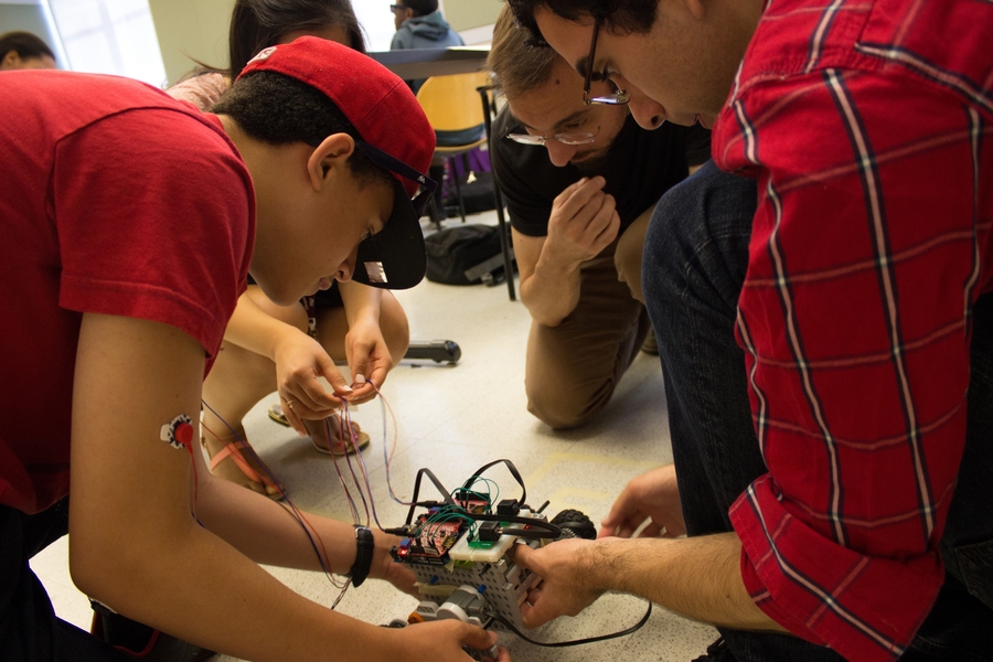 Students and instructors work together to build a robot they can control using the sensor on Lawrence student Jonathan Castillo’s arm.