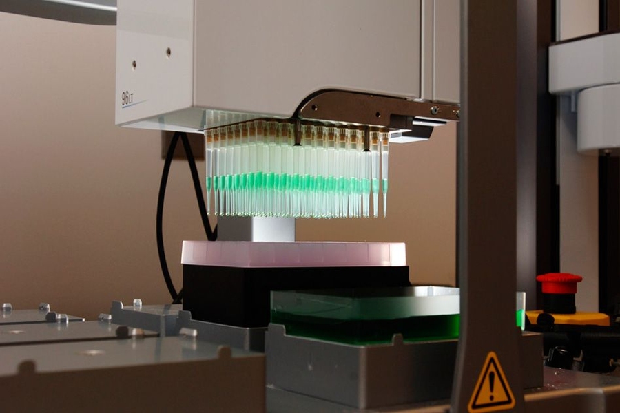 Gen9's BioFab platform synthesizes small DNA fragments on silicon chips and uses other technologies to build longer DNA constructs from those fragments. Done in a parallel, this produces hundreds to thousands of DNA constructs simultaneously. Shown here is an automated liquid-handling instrument that dispenses DNA onto the chips. 
