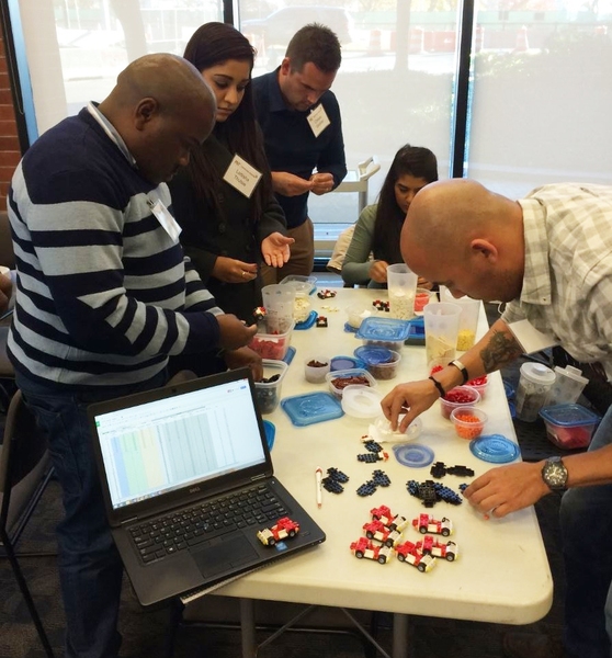 MIT Professional Education students from South Africa use Lego bricks in a manufacturing game to assemble small cars.
