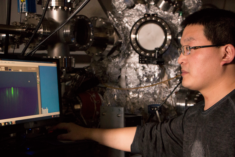 MIT postdoc Cui-Zu Chang works with equipment that can monitor topological insulator thin-film quality as it grows. The bright green vertical bar on computer screen is an indicator of very high-quality film growth. Chang led work in the Moodera group showing the first zero-resistance edge state in a circuit.