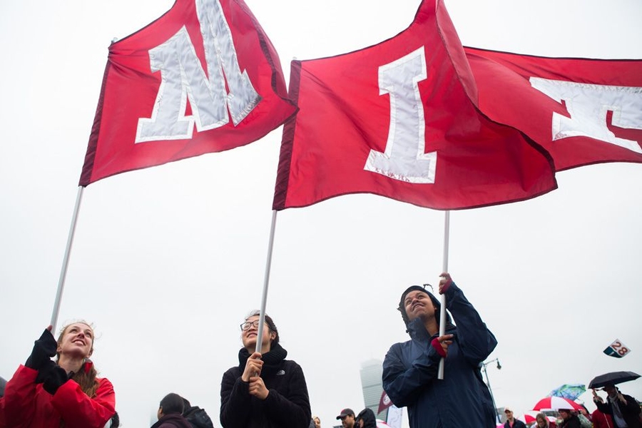 Students march with MIT flags.
