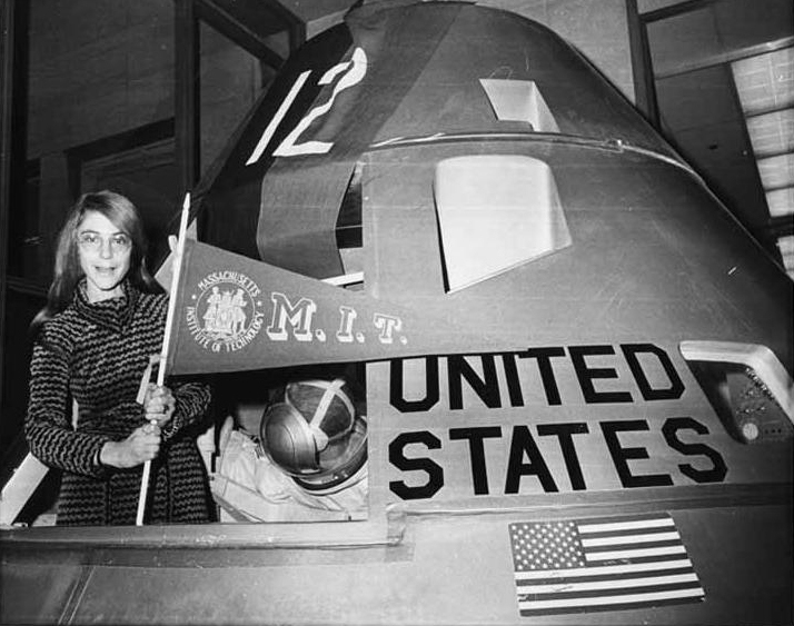 Margaret Hamilton poses with an MIT pennant inside an Apollo lunar capsule model. 