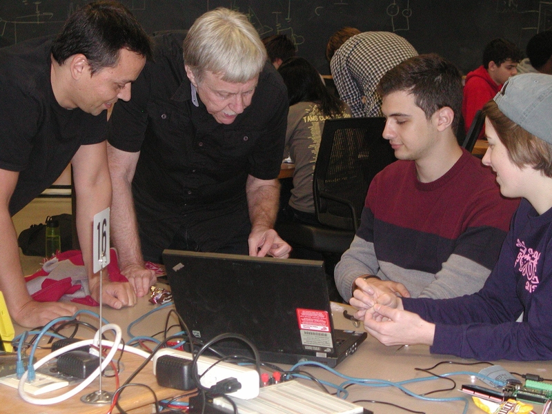 Postdoc Scott Page (left) and Dean for Undergraduate Education Dennis Freeman (center) troubleshoot with students during the motor debugging class.