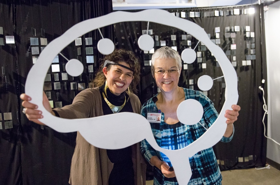 OpenMind::OpenArt Founder Jessica Artiles and MindHandHeart Executive Administrator Maryanne Kirkbride pose with the OMOA logo.