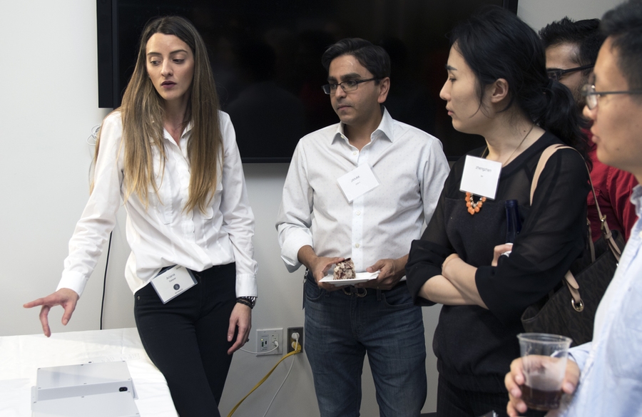 Ariana Salazar, team member of project BitSence, talks with attendees during a DesignX accelerator demo session. BitSence uses sensors and data analytics to help people who manage spaces better understand how their spaces are used. 