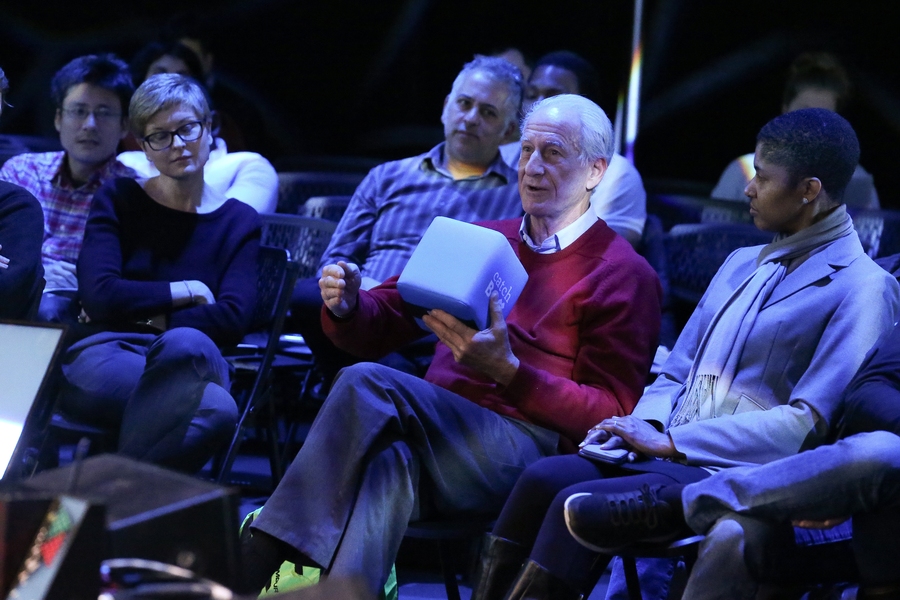 In the audience at Beyond the Cradle, Danielle Wood (right) listens to former NASA astronaut Jeff Hoffman (holding box), who’s now a professor in MIT’s Department of Aeronautics and Astronautics.