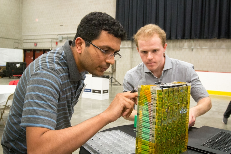 Eliot Owen (right) shows his design of a safe, high-performance cylindrical cell lithium-ion battery pack for an electric racecar.