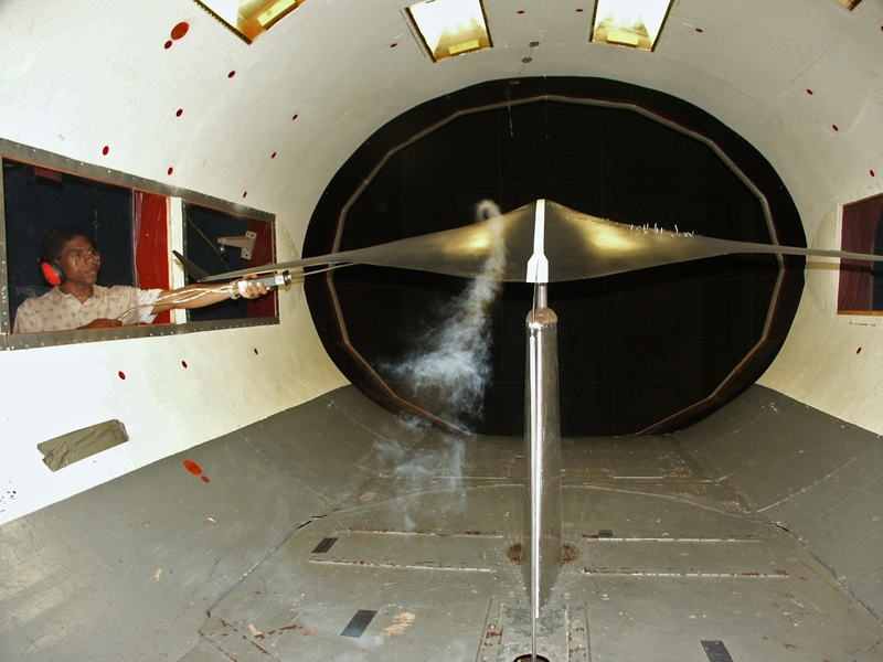 In this photo from 2004, AeroAstro student Chris Sequeira uses smoke to visualize air flow over the model of a blended wing body aircraft in the Wright Brothers Wind Tunnel.