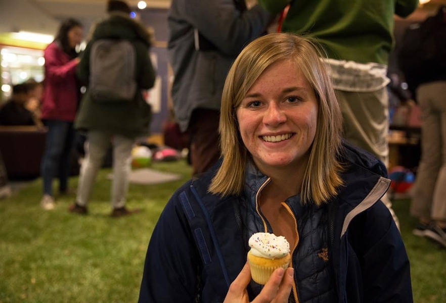 An MIT student enjoys cupcakes on the indoor lawn.