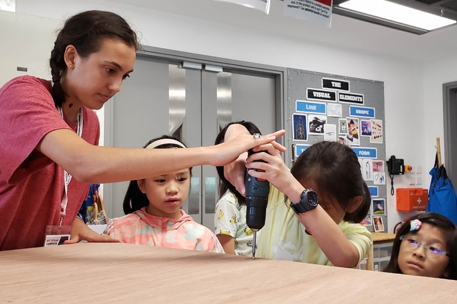 Young learners at the Chinese International School build their own project with guidance from rising MIT junior Rana Odabas.