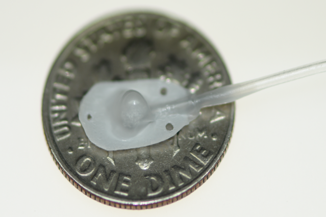 One of Professor Roche’s medical devices, Therepi, attaches directly to the damaged heart tissue to deliver drugs. The device is placed on a dime for size reference, and connected to a self-sealing subcutaneous port.